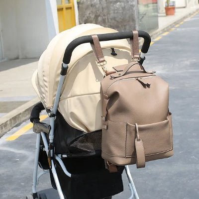 sac-a-dos-a-langer-beige-accroché-a-poussette