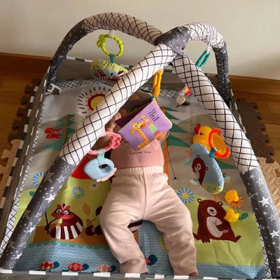 tapis-d'eveil-avec-jouet-accroché-et-un-bebe-qui-joue